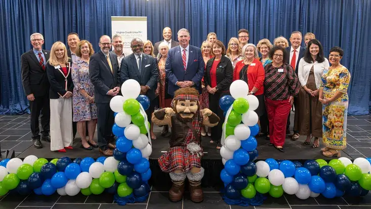 Employees of VACU and Radford University pose with mascot in celebration of center opening