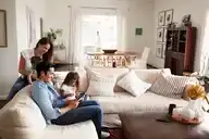 A family sitting on sofa together.