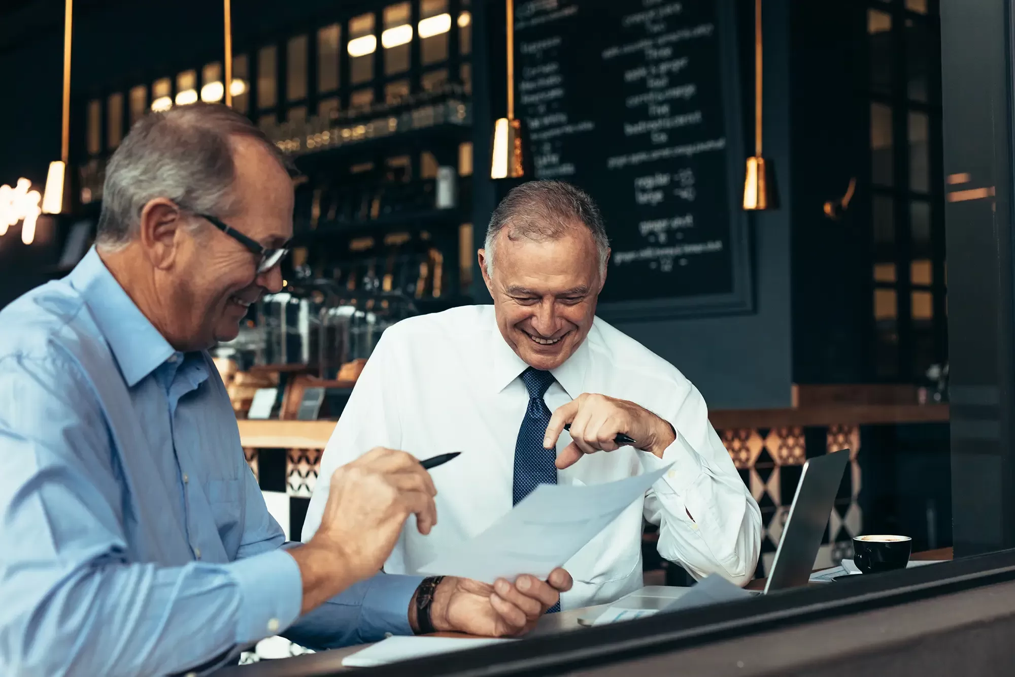 Adobe Stock 226861438 Business partners discussing reports at cafe copy
