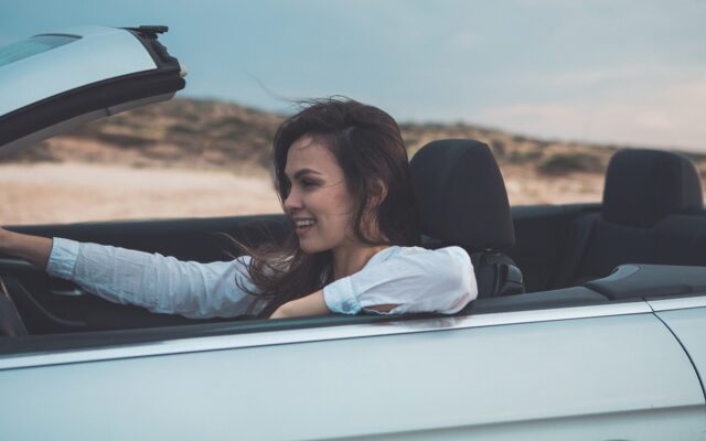 Woman drives convertible through desert scenery 978b8d064138018a1dfad71b9882dd21