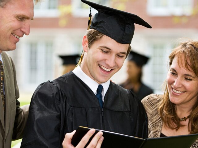 College graduate holding diploma with family 978b8d064138018a1dfad71b9882dd21