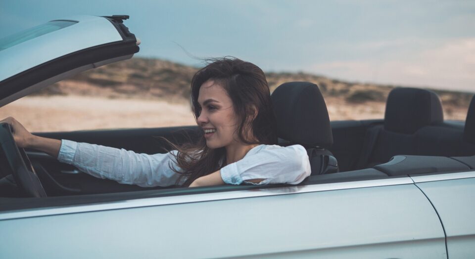 Woman drives convertible through desert scenery 978b8d064138018a1dfad71b9882dd21