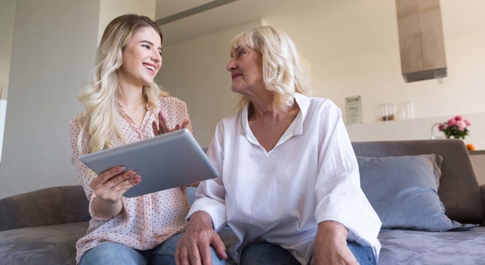 Young woman and grandmother looking at a tablet together 978b8d064138018a1dfad71b9882dd21