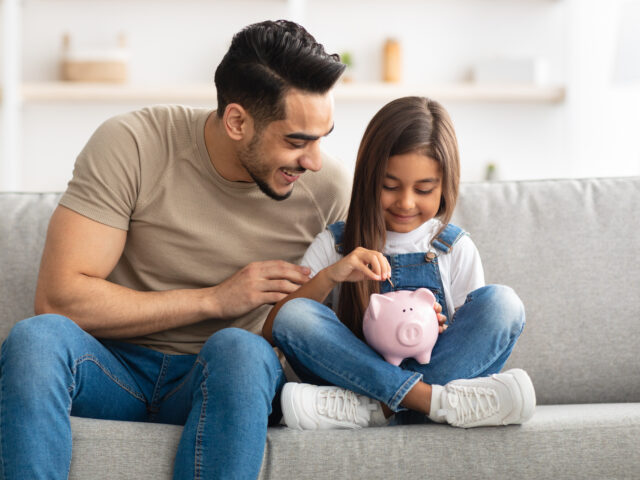 Dad and daughter with piggy bank
