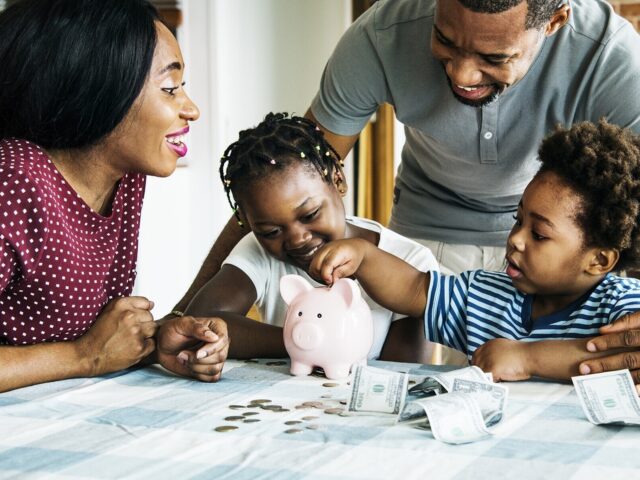 Parents help children count money in piggy bank 978b8d064138018a1dfad71b9882dd21